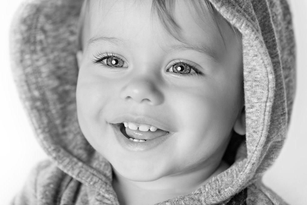 black and white of toddler boy smiling with hoodie